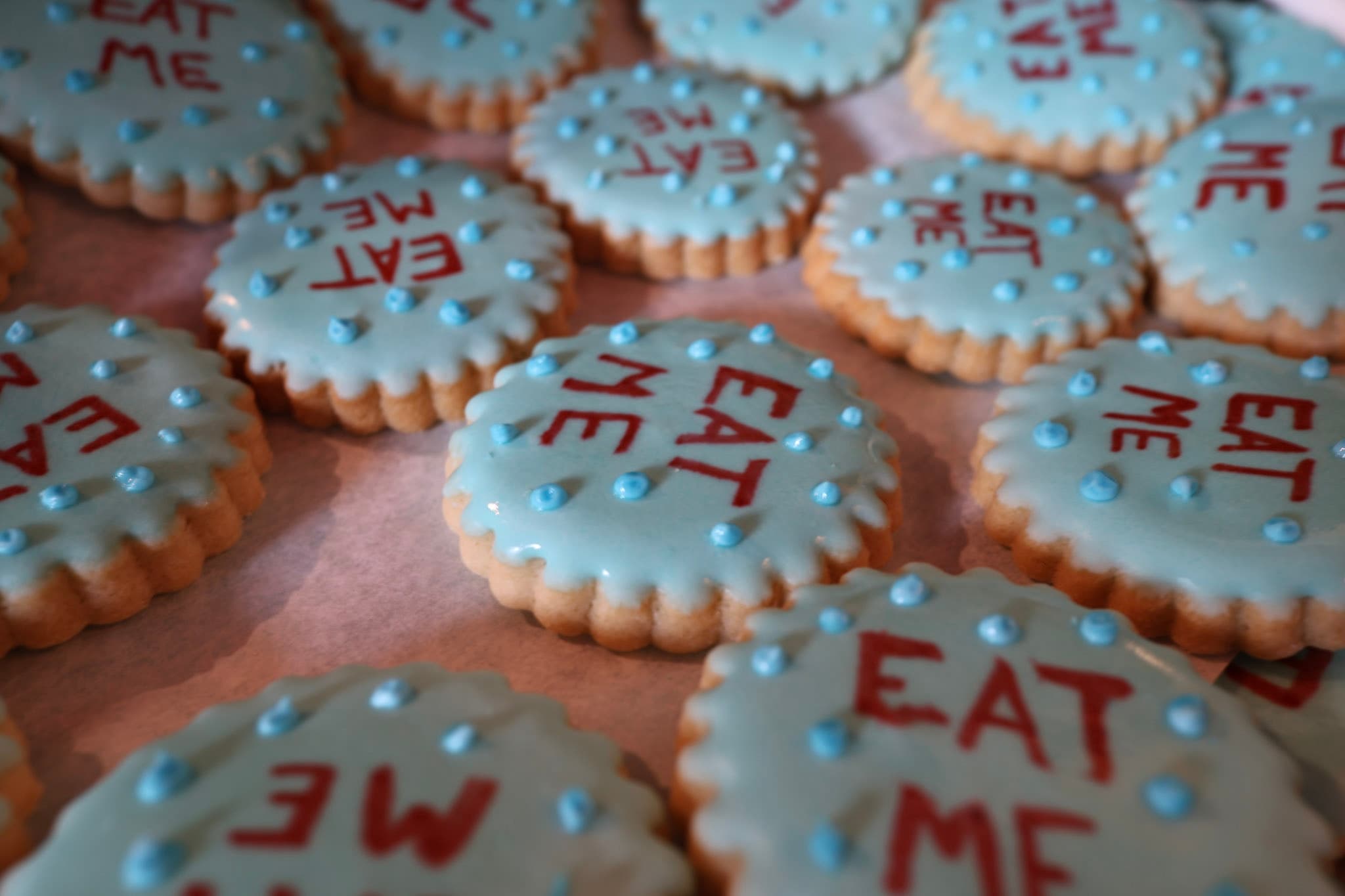 Tray of blue Eat Me iced cookies for guest check-in