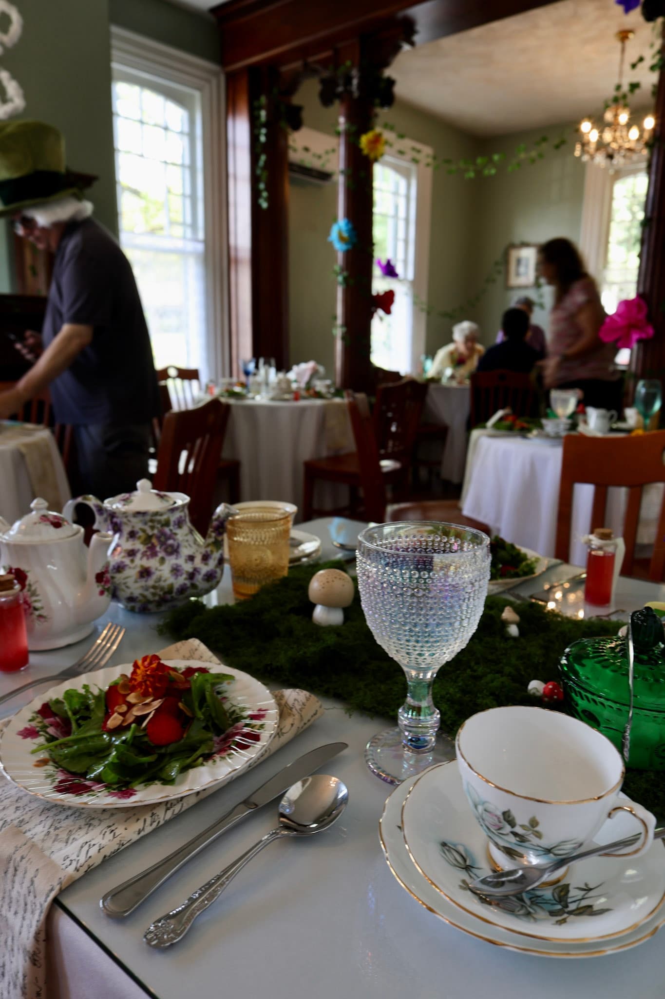 Garden salad place setting with moss runner, mushrooms, and Drink Me vial