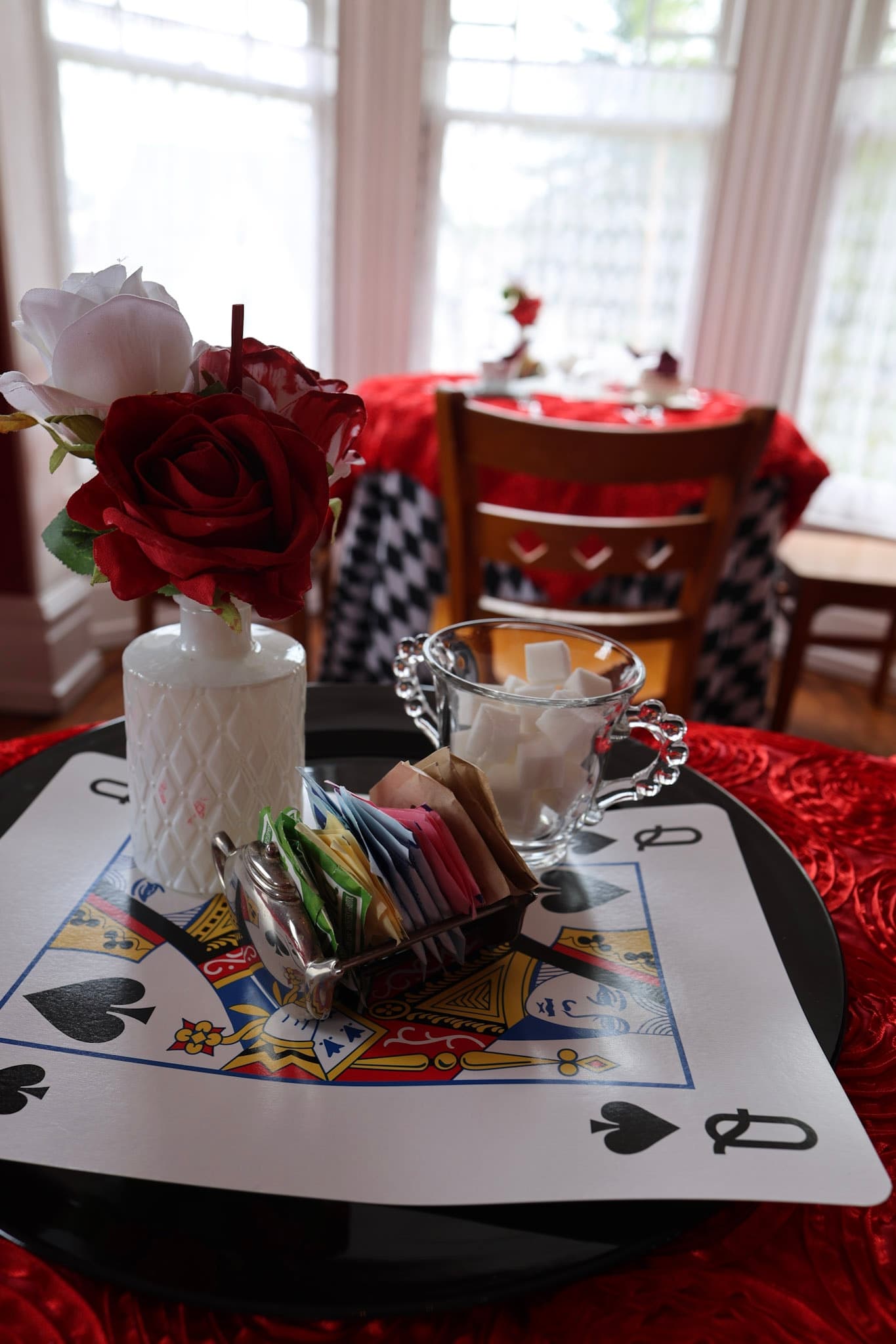 Red Queen painted roses and playing-card tablescape with harlequin linens