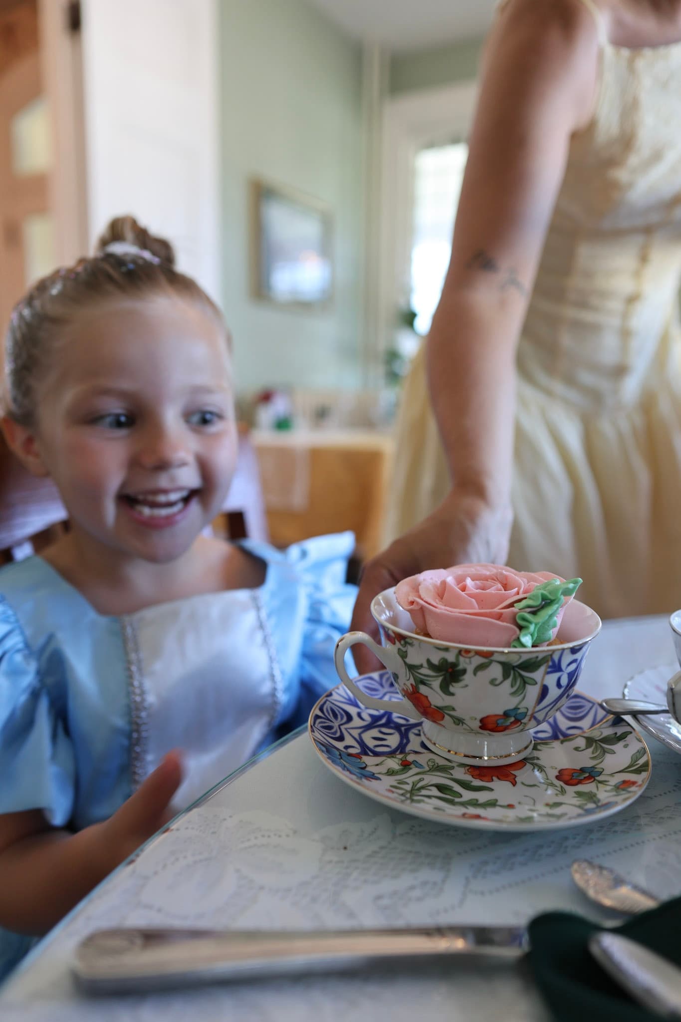 Rose cupcake served in a floral teacup during Alice afternoon tea